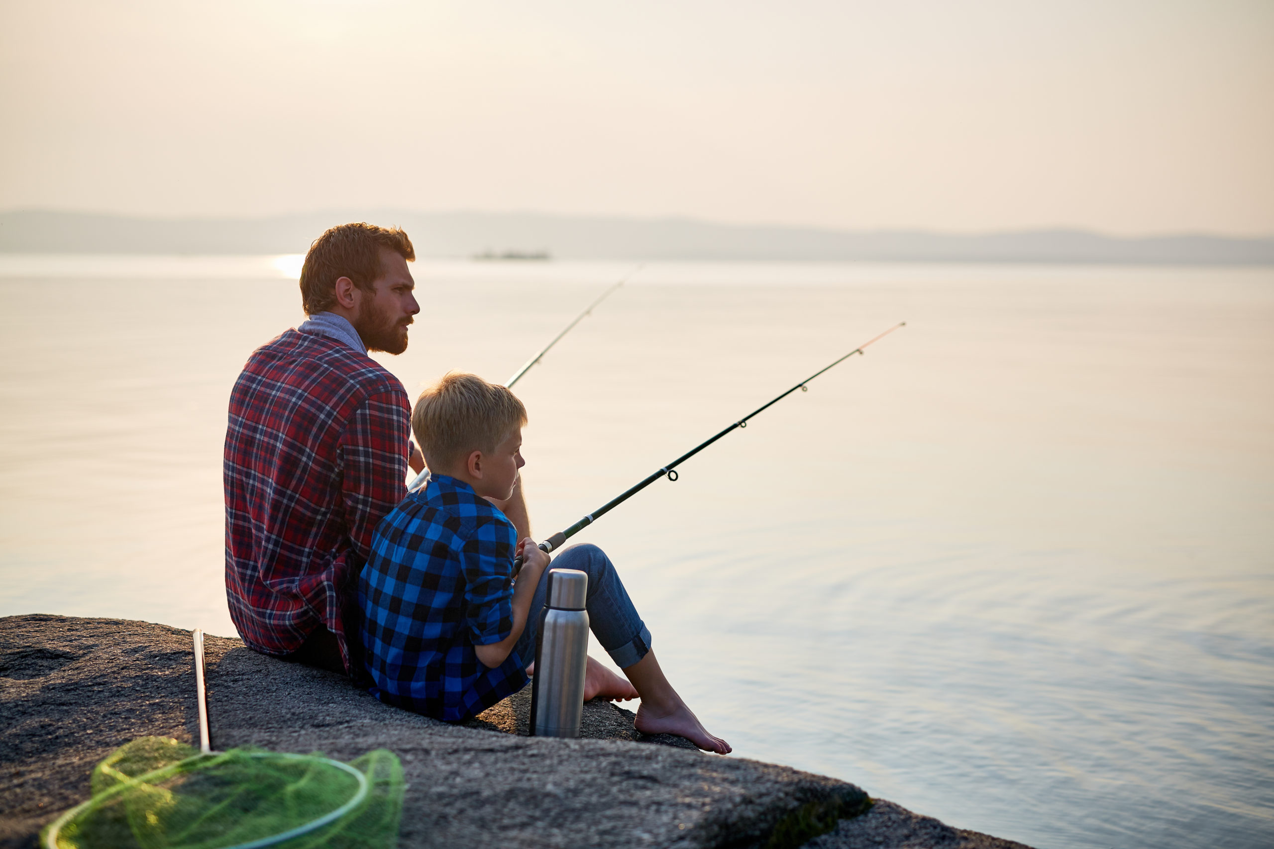 Сын ловит рыбу. Отец и сын рыбачат. Отец и сын на рыбалке. Папа с сыном на рыбалке. Рыбалка с сыном.